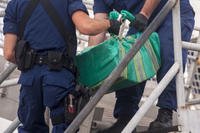 Crew members from the Coast Guard Cutter Mellon, a high-endurance cutter based out of Seattle, offload bales of cocaine from a bust at Coast Guard Base Los Angeles-Long Beach, Dec. 5, 2014. (U.S. Coast Guard photo by Petty Officer 1st Class Adam Eggers)