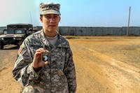 Army Cpl. Nicole Mattoon shows off the coin she received from Army Maj. Gen. Volesky, commander of Joint Forces Command United Assistance. (U.S. Army photo by Spc. Caitlyn Byrne)