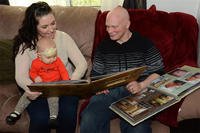 Staff Sgt. Richard L. Johnson and his wife, Christa, look at two scrapbooks with their daughter, Ayda, inside their home Feb. 13, 2014, in California. (U.S. Air Force photo/Tech. Sgt. James M. Hodgman)
