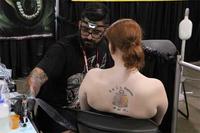 A member of the U.S. Navy sits for a tattoo with one of the many renowned tattoo artists who travel annually to the Pacific Ink &amp; Art Expo, Blaisdell Exhibition Hall, Honolulu, Hawaii, Aug. 3, 2013. (U.S. Air Force photo by Tech. Sgt. Phyllis Keith)