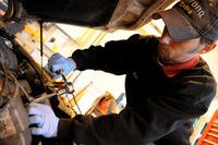 Fixing an engine with a wrench.