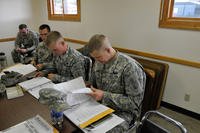 Soldiers studying at a desk.
