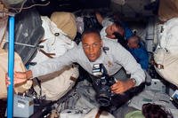 Specialist Alvin Drew Jr. holds a camera in space.