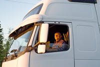 Truck driver in a white cab.