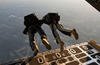 U.S. Navy SEALs exit a C-130 Hercules aircraft.