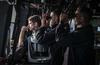 U.S. Navy officers scan the horizon from the bridge of the USS Green Bay