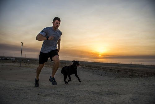 An airman runs with his dog at an undisclosed location in Southwest Asia.