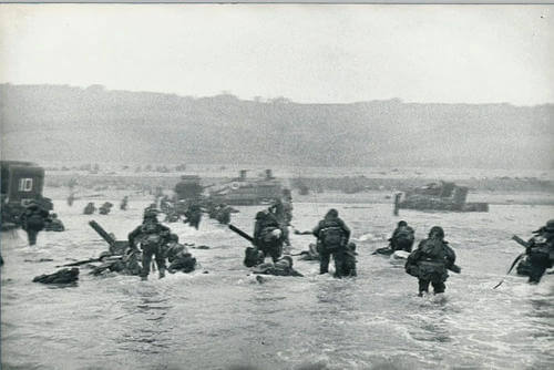 One of war photographer Robert Capa’s images shows a wave of troops arriving on the Normandy beaches on D-Day.
