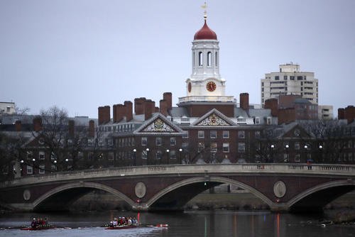 Rowers paddle down the Charles River near the campus of Harvard University in Cambridge, Mass.