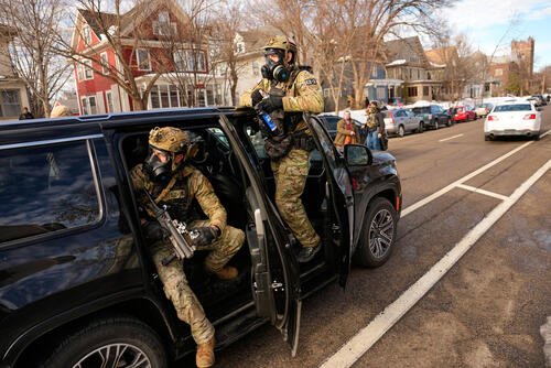 Federal immigration officers get in a car as they prepare to deploy tear gas at a protest, Monday, Jan. 12, 2026, in Minneapolis. (AP Photo/John Locher)