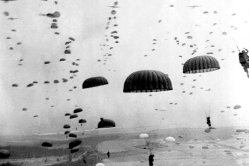 Parachutes open overhead as waves of paratroops land in Holland during operations by the 1st Allied Airborne Army. (Photo: National Archives)